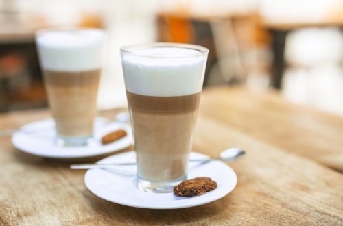 two-cappuccino-coffee-glasses-with-spoon-saucer-wooden-table